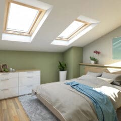 A cozy bedroom with a slanted ceiling and two skylights illuminating the space. The room features a bed with a beige comforter and blue throw, a white dresser with a woven basket and decor on top, and potted plants enhancing the serene atmosphere.